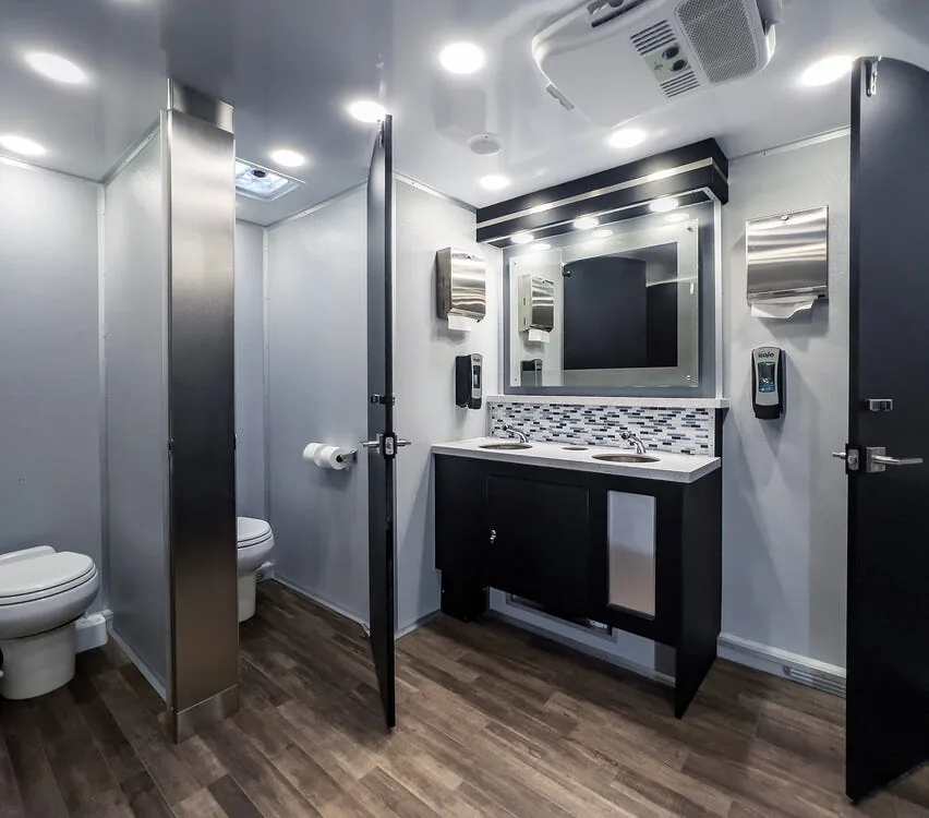 Restroom interior with floor-to-ceiling stall doors and a double vanity.