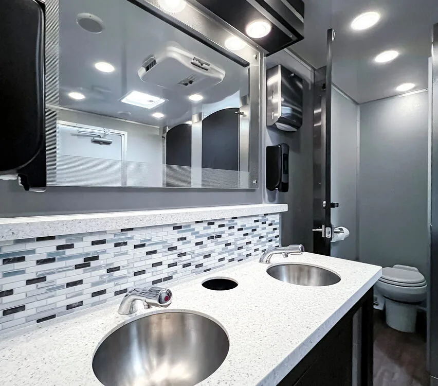 Double sink vanity with mosaic backsplash.