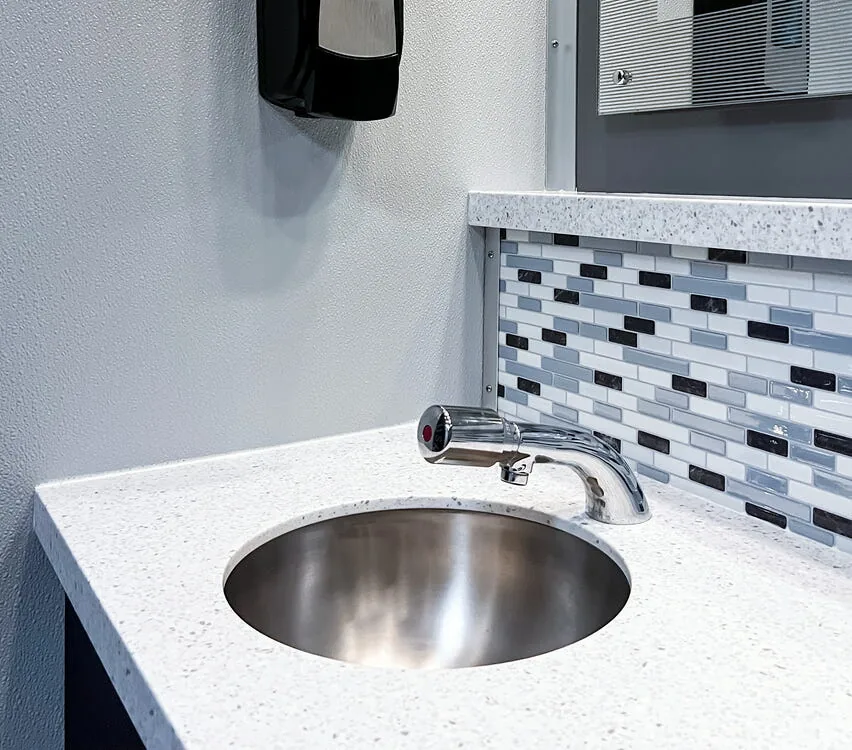 Stainless steel sink with soap dispenser.