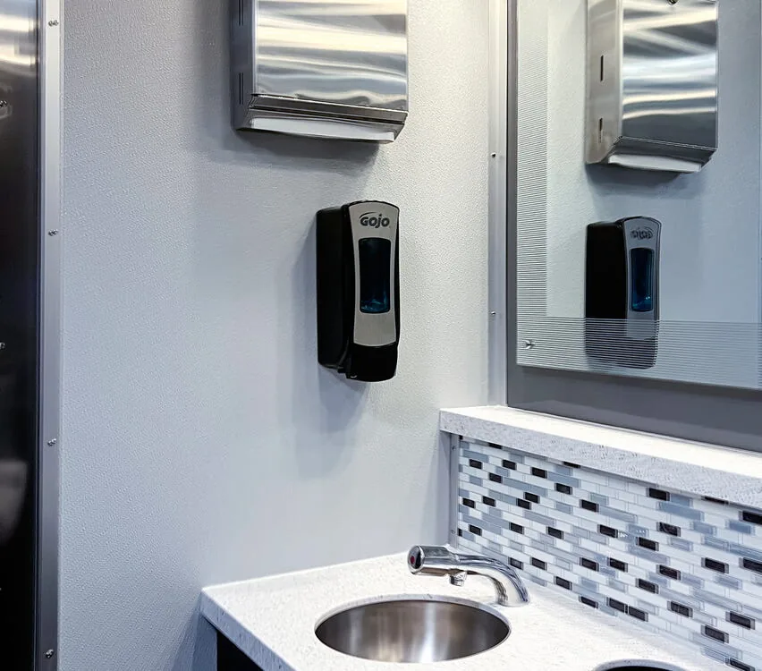 Sink with paper towel and soap dispensers.