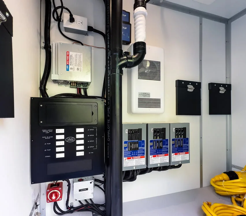 Utility closet with electrical panel and plumbing.