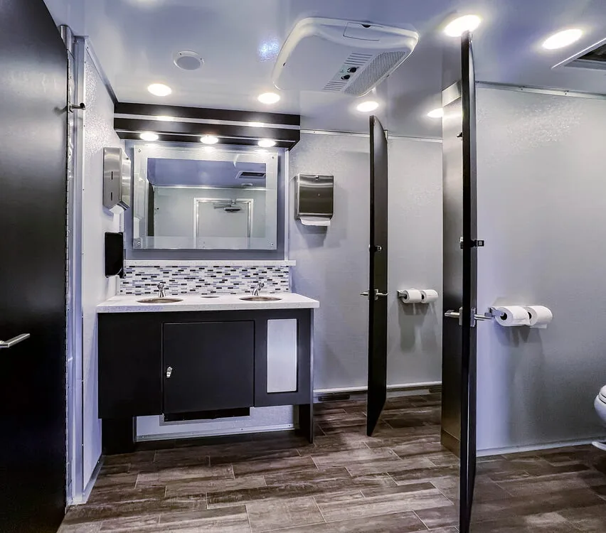 Restroom interior with a vanity and stall doors.