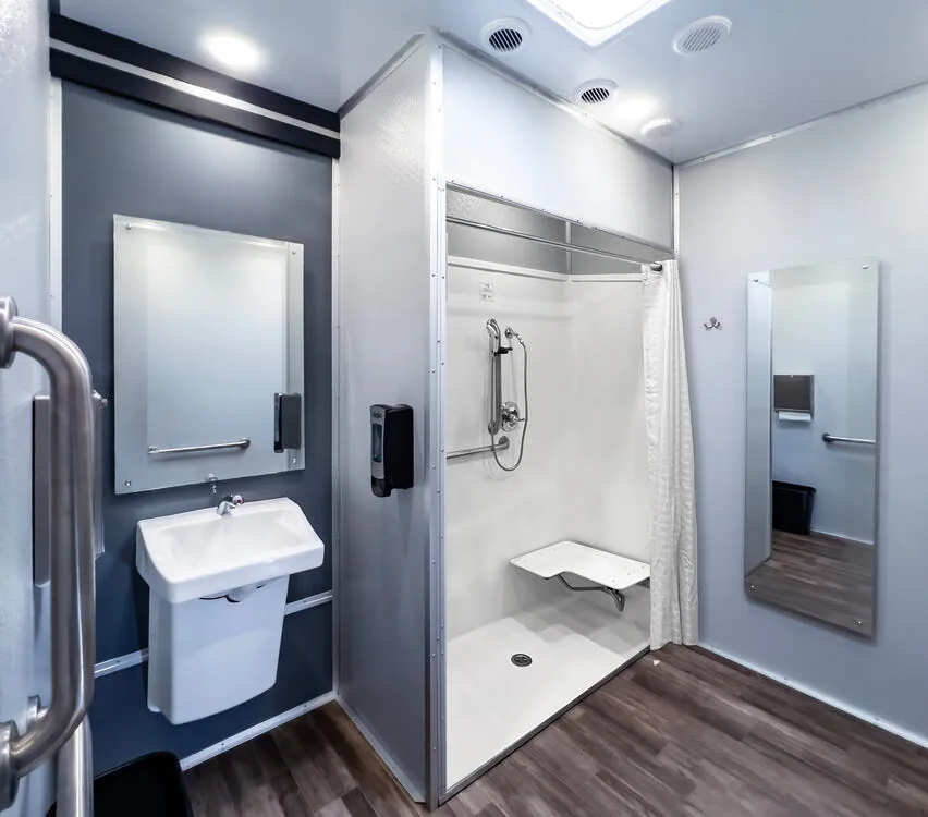 Accessible restroom with sink, assist bars and shower.