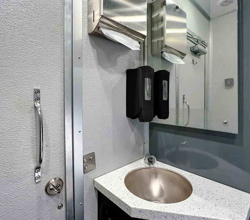 Sink with mirror and soap dispenser.