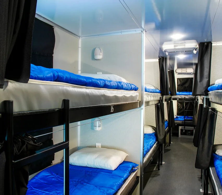 Rows of bunk beds with privacy curtains.