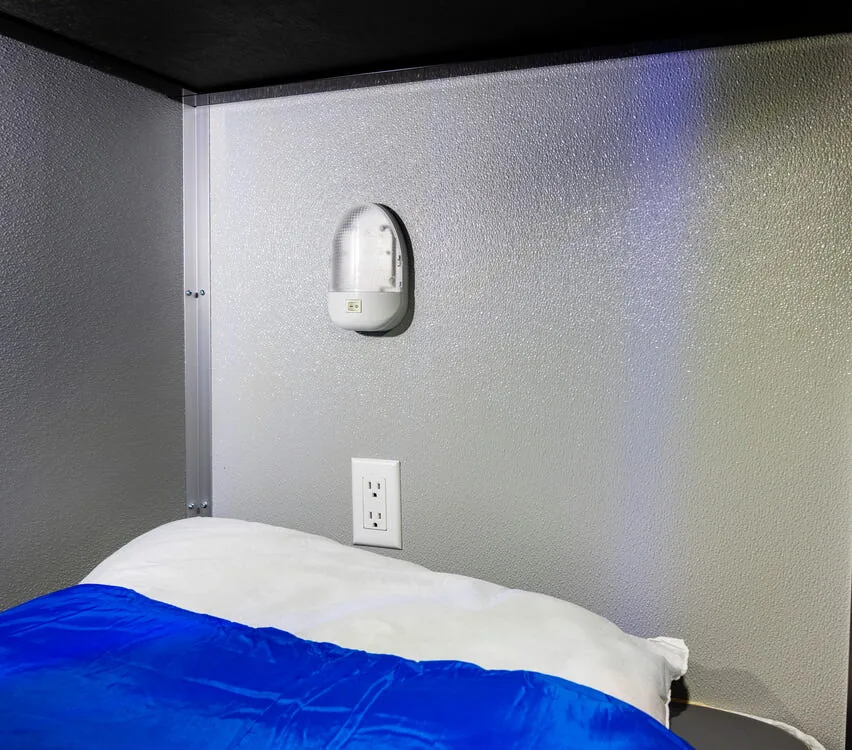 Bunk with a receptacle and reading light.