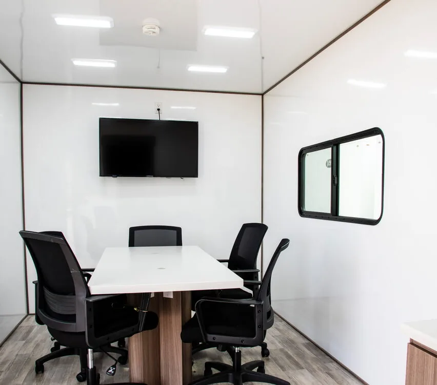 Conference room with table, chairs and video monitor.