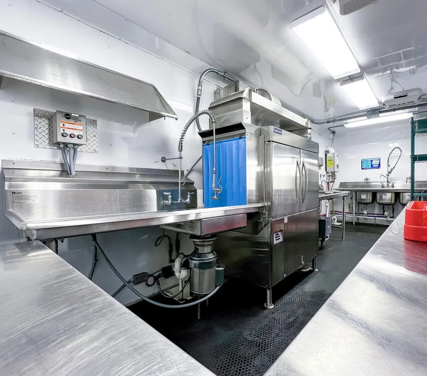 Stainless steel tables leading to the dishwashing machine.