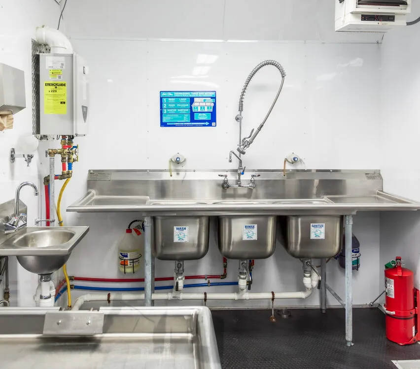 Three-compartment sink with drain boards.