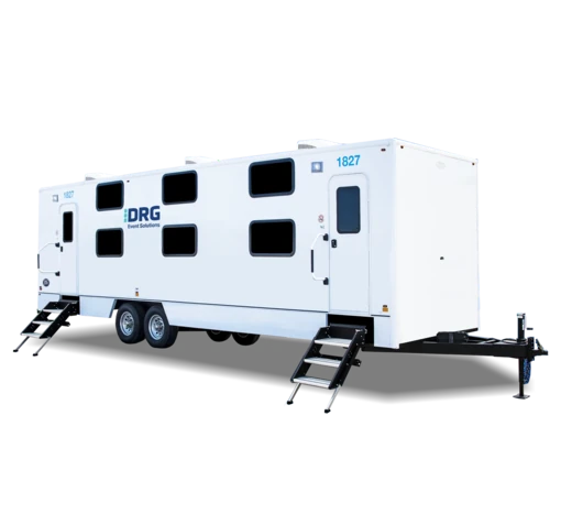 White DRG 16-bed sleeper trailer with two sets of stairs.