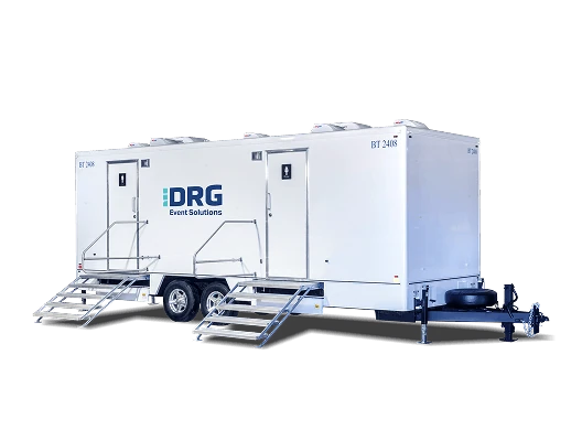 Three-stall white DRG restroom trailer with aluminum stairs.